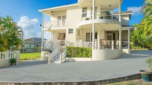 A multi-story house with a circular central section, balconies, and a covered outdoor area. - Sunset Nook: Cozy one bedroom apartment

 (Saint James)