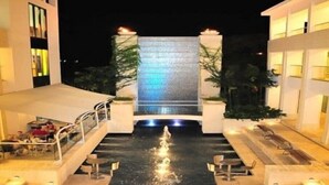 A modern hotel with a central water feature, outdoor seating, and a well-lit facade. - Sunset Nook: Cozy one bedroom apartment

 (Saint James)
