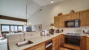 A modern kitchen with wooden cabinets, a built-in oven, a microwave, and a dishwasher. - Mammoth Lakes Condo: Walk to Village & Gondola! (Mammoth Lakes)