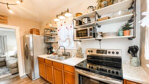 A modern kitchen with stainless steel appliances, wooden cabinets, and a white countertop.