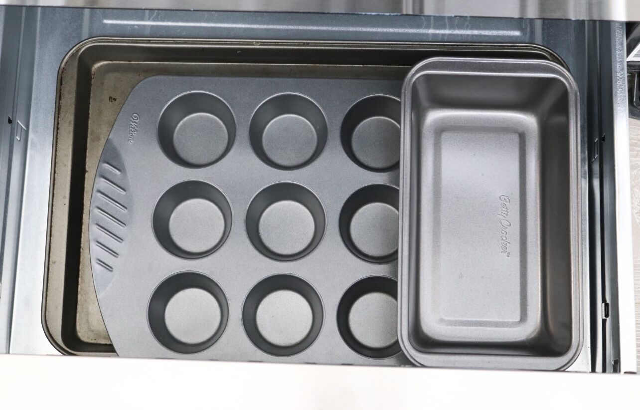 Una cocina con una bandeja para muffins y un recipiente rectangular para hornear.