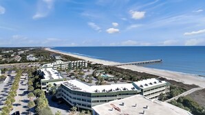 Un hotel costero con varias edificaciones, estacionamiento y vista a la playa.