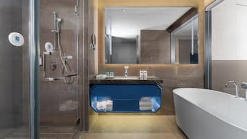 Un baño moderno con ducha acristalada, un espejo grande y una bañera.