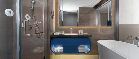Une salle de bain moderne avec une douche à parois de verre, un grand miroir et une baignoire.