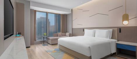 Una habitación de hotel moderna con una cama grande, televisor, sofá y vistas a la ciudad.