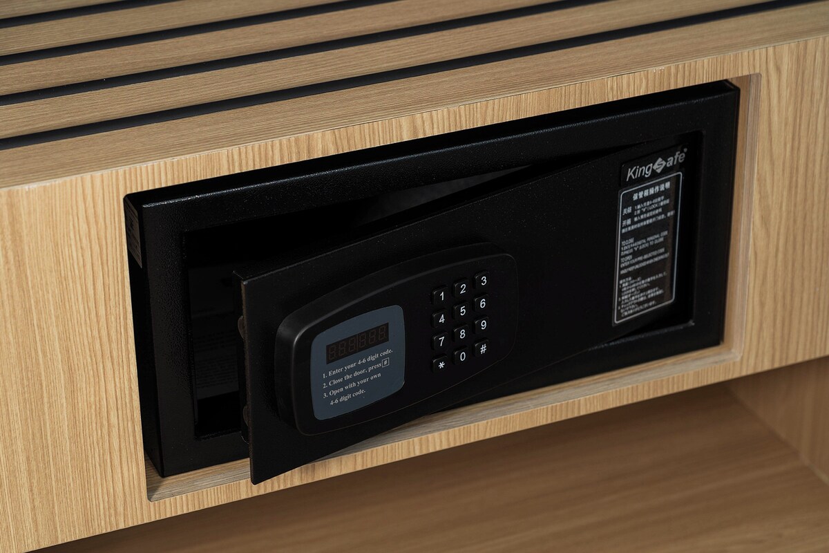 A black electronic keypad with a digital display and instructions for use, integrated into a wooden cabinet.