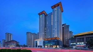 A high-rise hotel with multiple floors, large windows, and a prominent entrance.