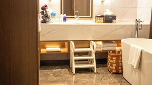 A bathroom with a white bathtub, a sink with toiletries, and a mirror. - voco Xi'An Qindu Legend by IHG (Xi'an)