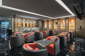 A modern bar area with seating, a bar counter, and shelves with bottles. - voco Xi'An Qindu Legend by IHG (Xi'an)