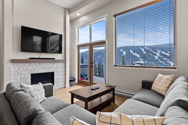 Relax in this cozy living space with a fireplace, flat-screen TV, and comfortable sofa.