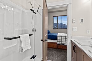Enjoy a refreshing shower in this bathroom with a glass enclosure and a convenient sink.