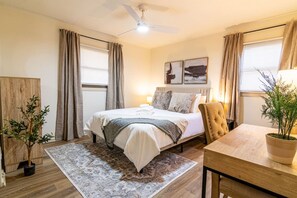 A bedroom with a bed, a chair, a table, a ceiling fan, and a potted plant. - Hamilton Modern Organic 3Bed 3Bath Noblesville (Noblesville)