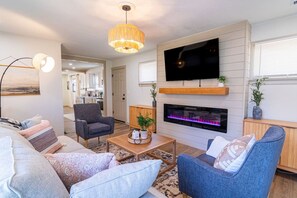 A modern living room with a flat-screen TV, fireplace, and comfortable seating. - Hamilton Modern Organic 3Bed 3Bath Noblesville (Noblesville)