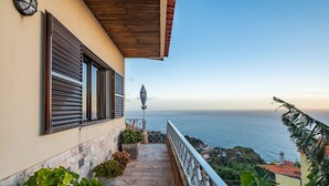 A balcony with a view of the sea, a lamp post, and potted plants. - White Rabbit I by Madeira Sun Travel (Calheta)
