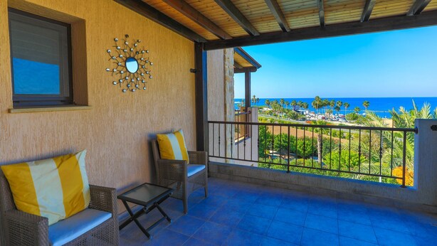 A balcony with wicker furniture, a decorative mirror, and a view of the ocean. - 3 Bedroom Villa, Private Pool, 250m to Latchi Beach (Latchi)