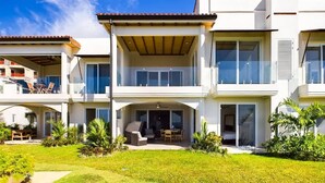 A modern two-story house with a covered patio, a lawn, and a small garden area. - Condo Mirador-Breathtaking Ocean View (Tamarindo)