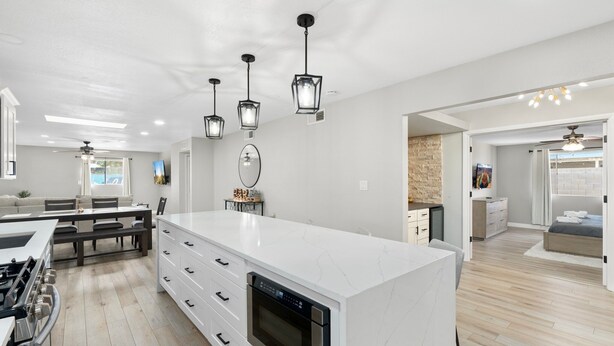 A modern kitchen with a large island, built-in oven, and pendant lighting. - 4 Bed Mid Century Modern w/ Pool, Putting Green, Wood Fired Pizza Oven, Sleeps 9 (Phoenix)