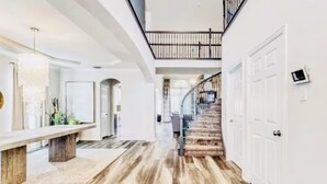 Un hall d’entrée spacieux, doté d’un plancher en bois, d’un banc et d’un escalier menant à l’étage supérieur.