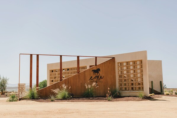A modern building with a wooden facade, a horse logo, and a reception desk.