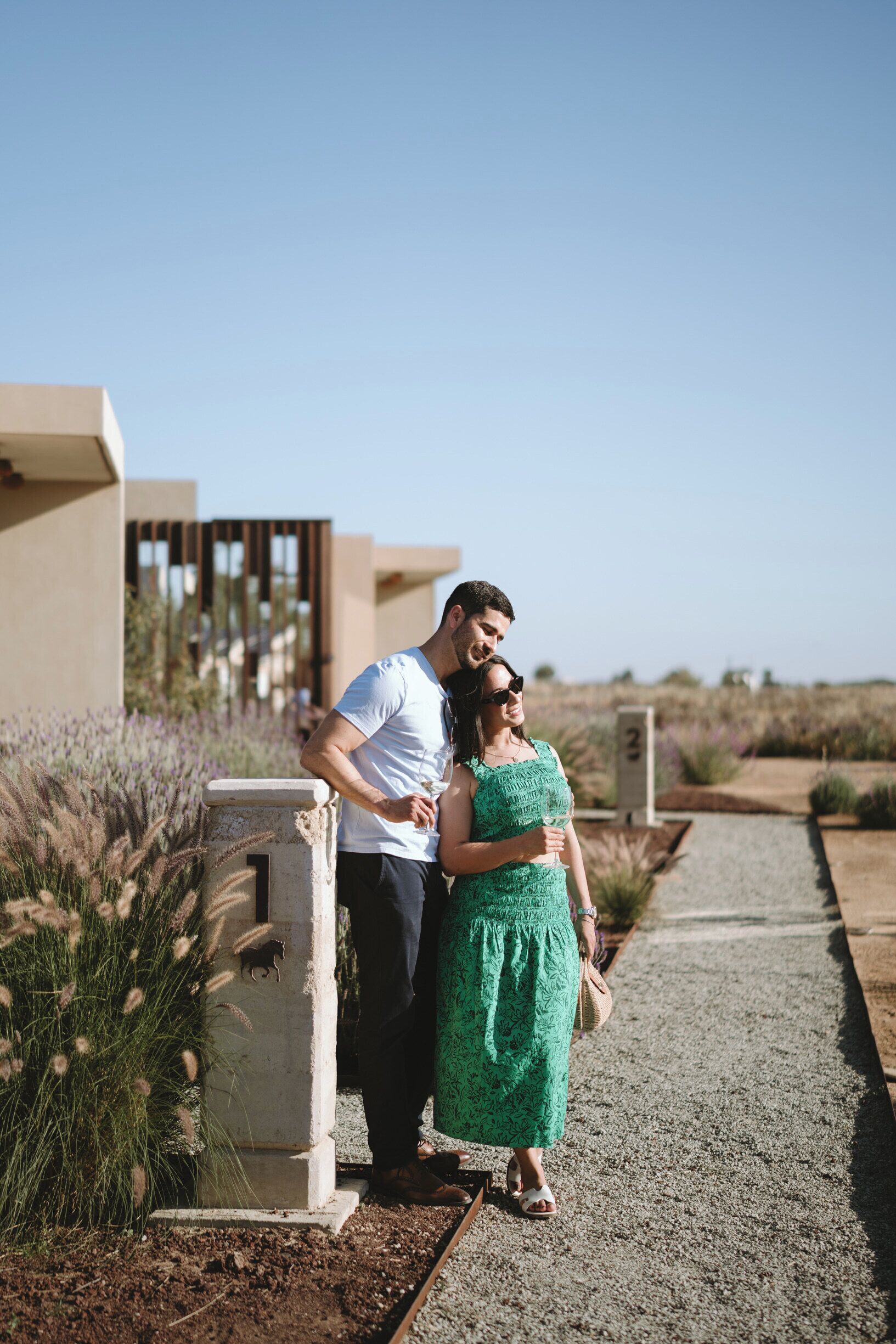 A couple standing by a modern building with a clear sky.