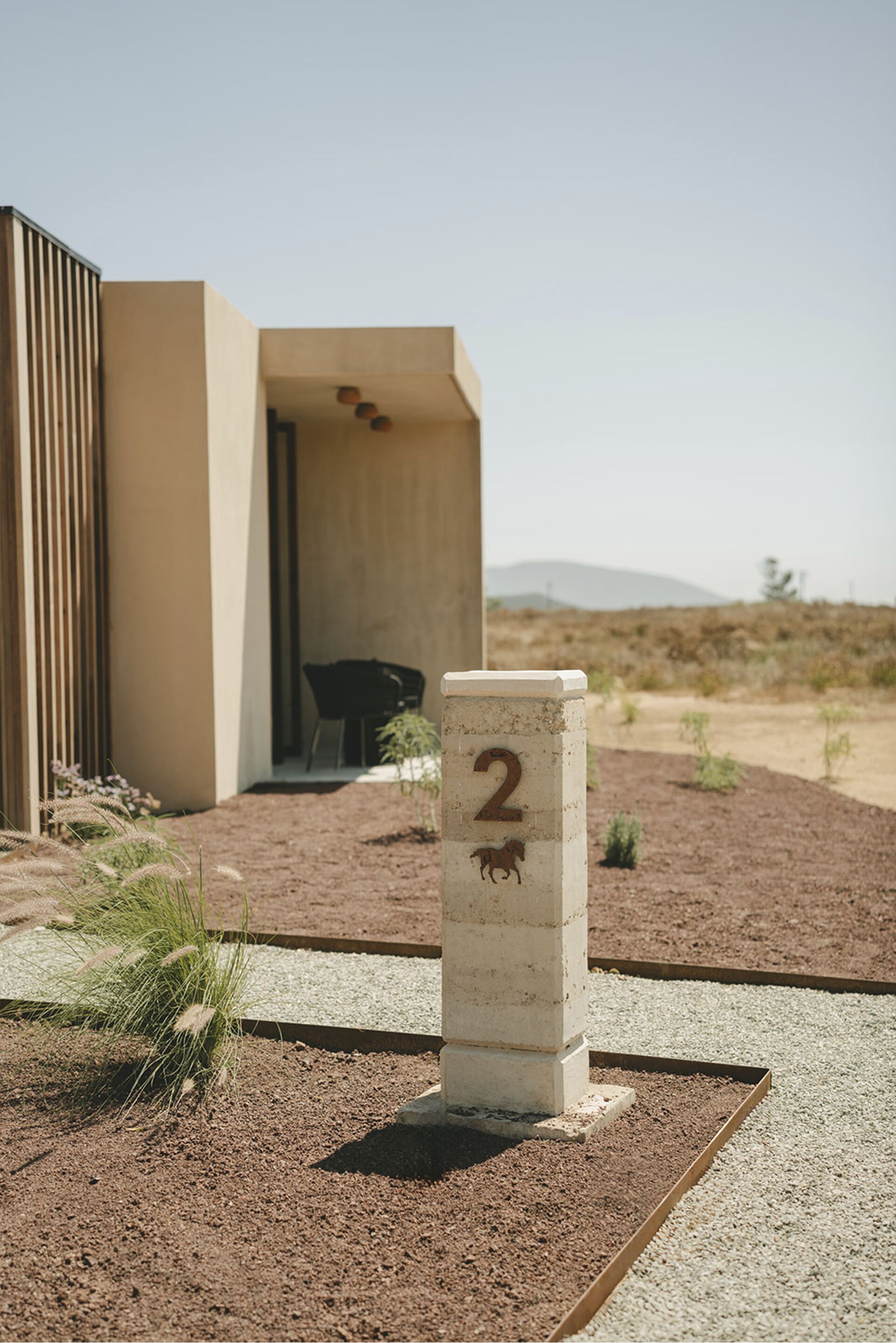 A concrete pillar with the number 2 and a horse symbol, indicating a property number.
