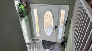 A staircase leading to a door with a decorative glass panel and a welcome mat. - Freshly updated house with a clean and spacious feel.( 3 bdr 3 bath 9 ppl.) (Long Pond)