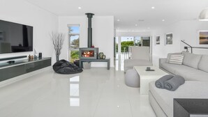 Una sala de estar moderna con una televisión de pantalla plana, una chimenea, un sofá y una mesa de centro.
