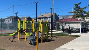 A playground with climbing structures and a covered seating area. - Fun shore bungalow that is walkable to the beach!  (Lavallette)