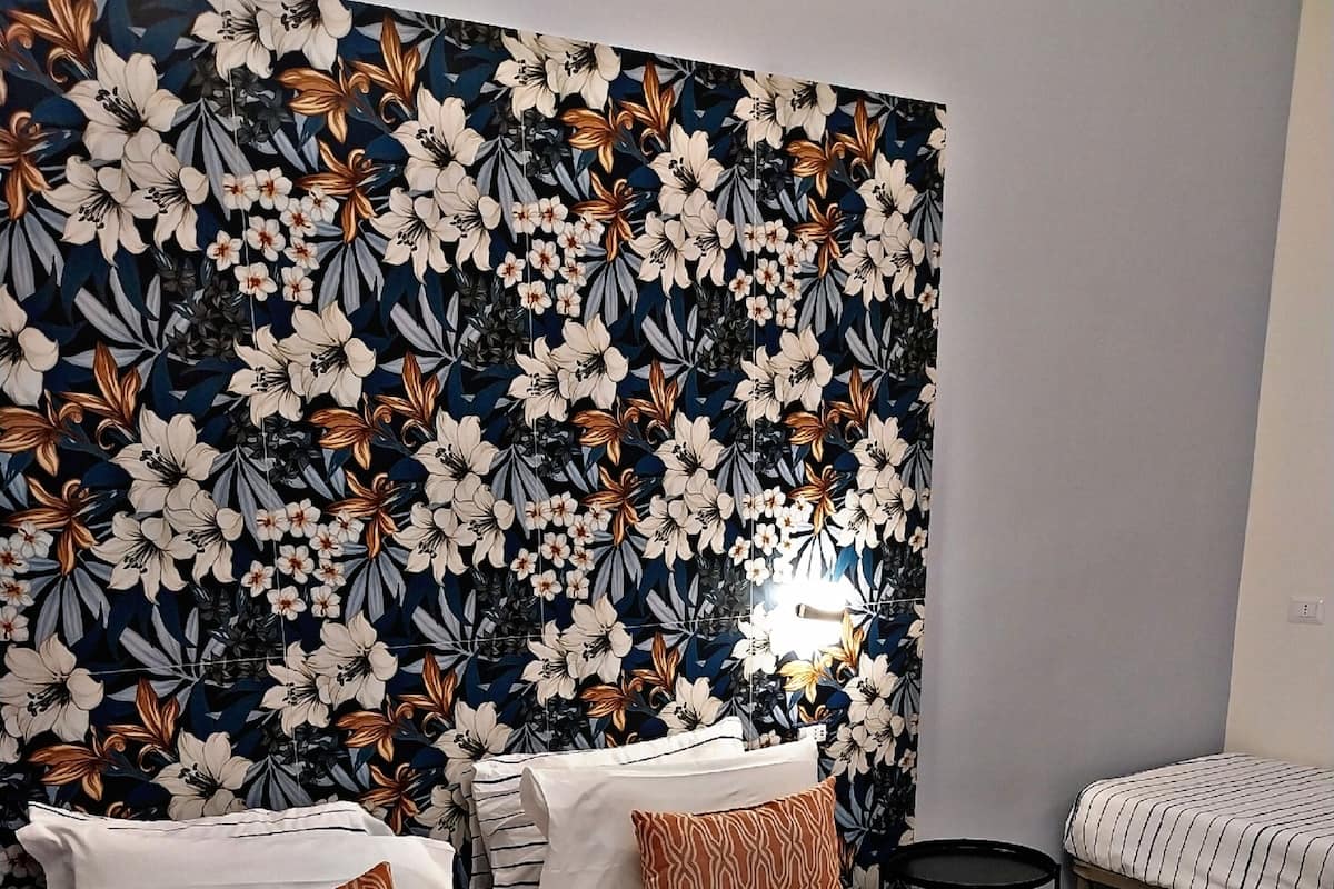 Ein Hotelzimmer mit einem großen Bett, gestreifter Bettwäsche und zwei Kissen.