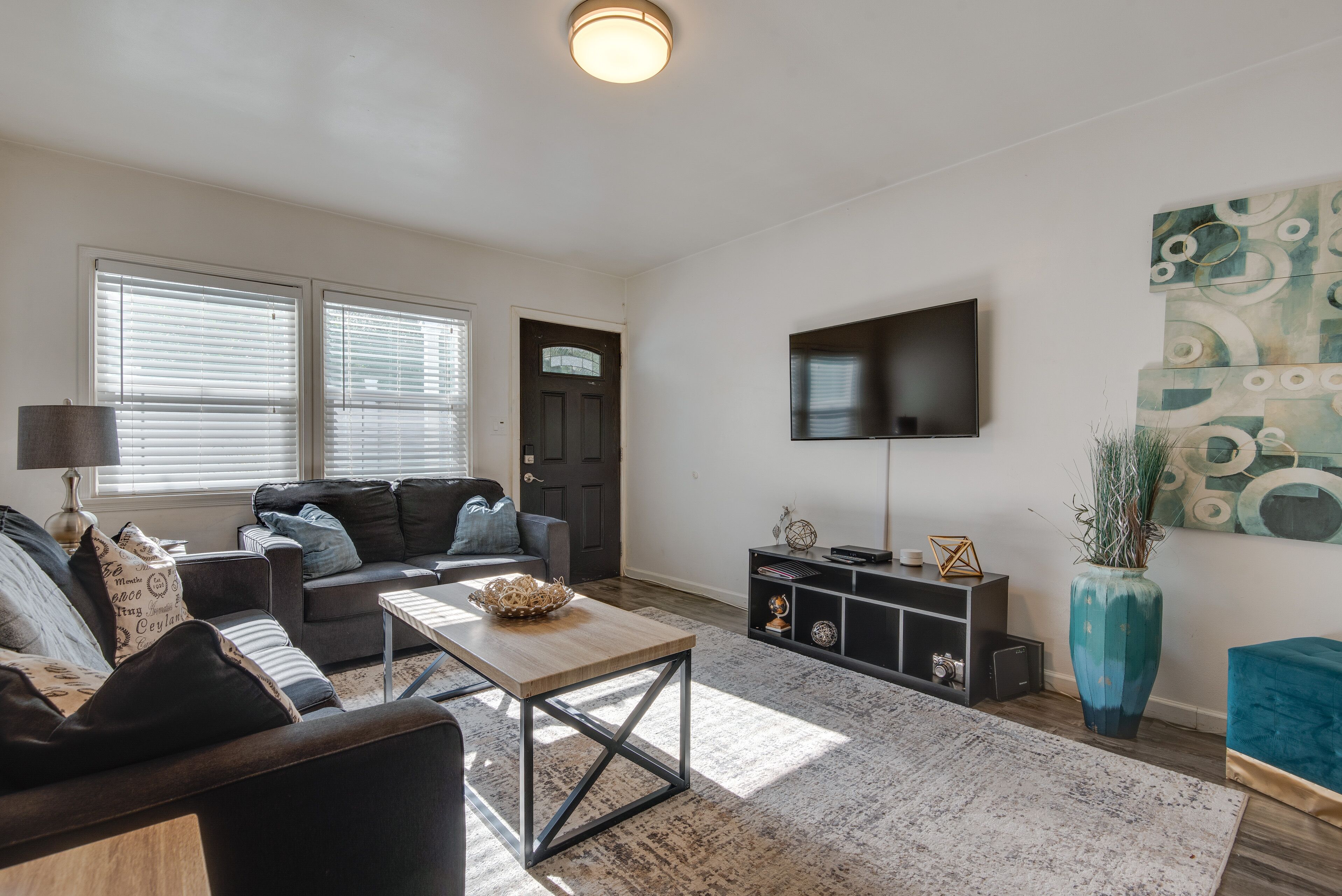 Een woonkamer met een bank, salontafel, televisie en decoratieve objecten.