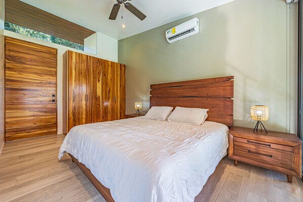 Ein Schlafzimmer mit einem hölzernen Bett, einem Nachttisch, einer Lampe und einem Deckenventilator.