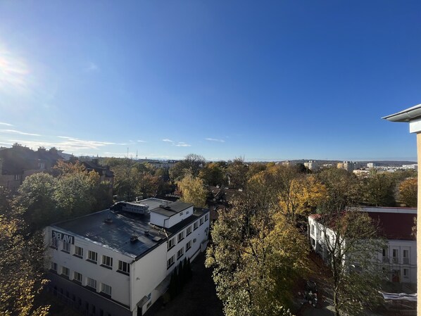 A building with a flat roof and multiple windows, surrounded by trees with autumn foliage. - Ferienwohnung Ruhig, Zentrumsnah (Kraków)