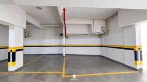 A multi-purpose indoor space with a grey floor, white walls, and yellow and black striped lines marking the floor. - Apto Panorâmico Vista Mar em Itapema (Itapema)