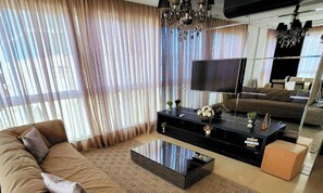 Departamento Deluxe, vista a la playa | Área de sala de estar | Smart TV, Netflix, películas con cargo y servicios de streaming 