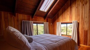 A wooden room with a bed, large windows, and a skylight. - Mountain Wonders Chalet: Perfect to enjoy nature (Provincia de Puntarenas)