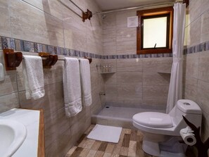 Casa de banho com chuveiro, sanita e lavatório.