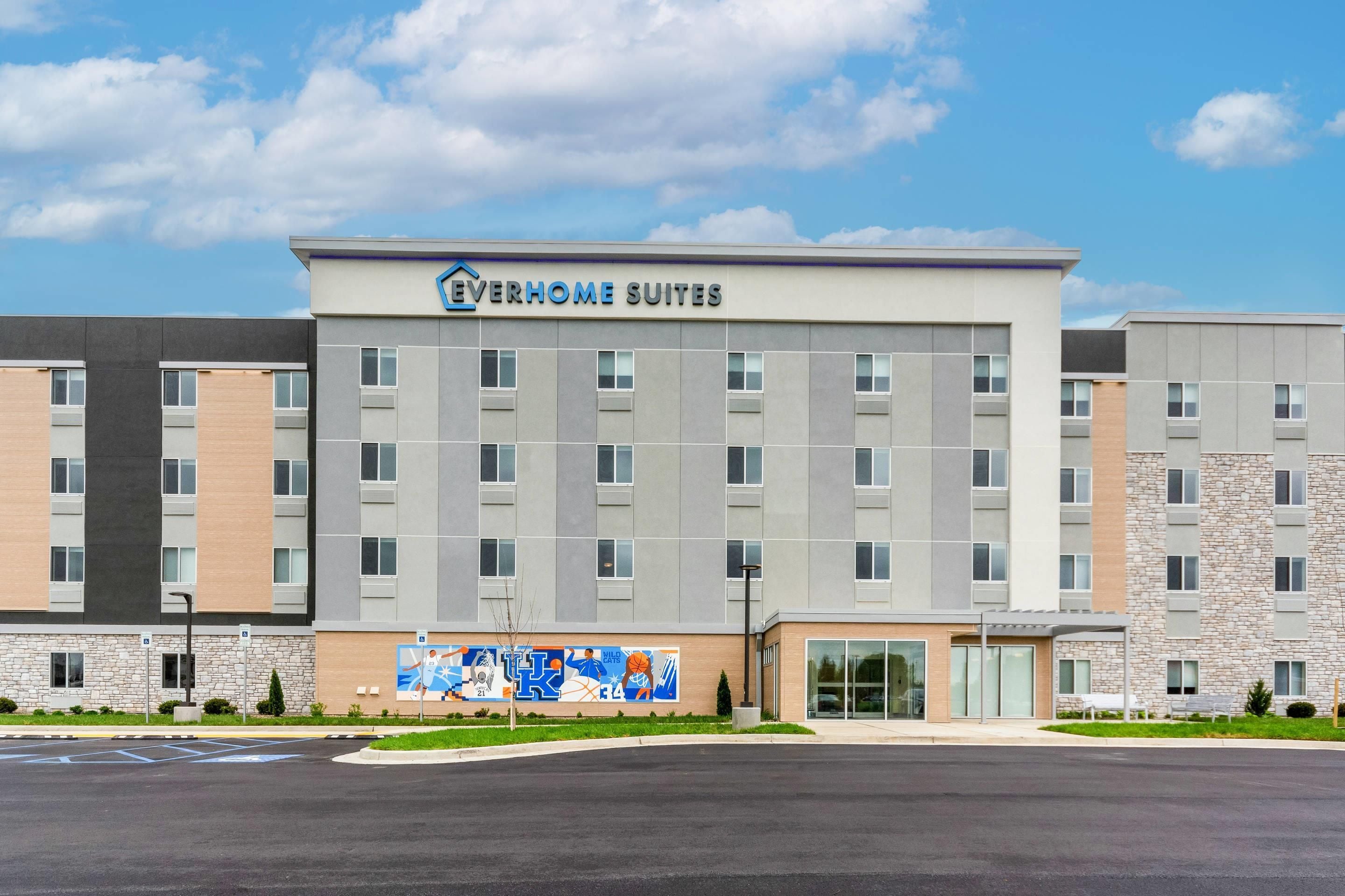 A multi-story hotel building with a sign reading 'EVERHOME SUITES'.