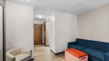 A modern interior with a sofa, a chair, and a wooden door.