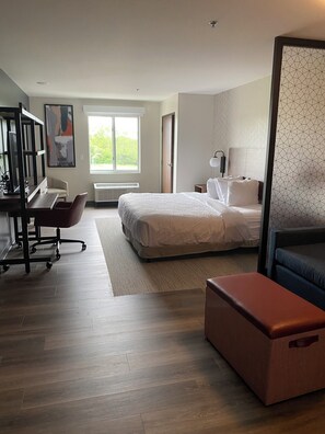 A modern bedroom with a large bed, a desk, and a chair. - Everhome Suites Lexington - Horse Park (Lexington)
