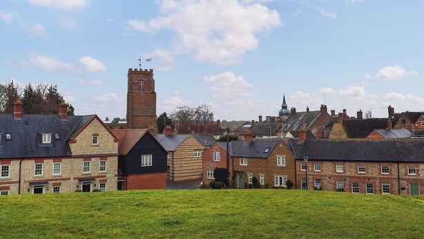 Une ville historique, avec ses bâtiments traditionnels, son imposante tour et le clocher de son église.