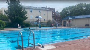 A swimming pool with diving boards, a lifeguard stand, and a ladder. - ⭐Cozy 1-Bed⭐Minutes to NYC/PATH (Jersey City)