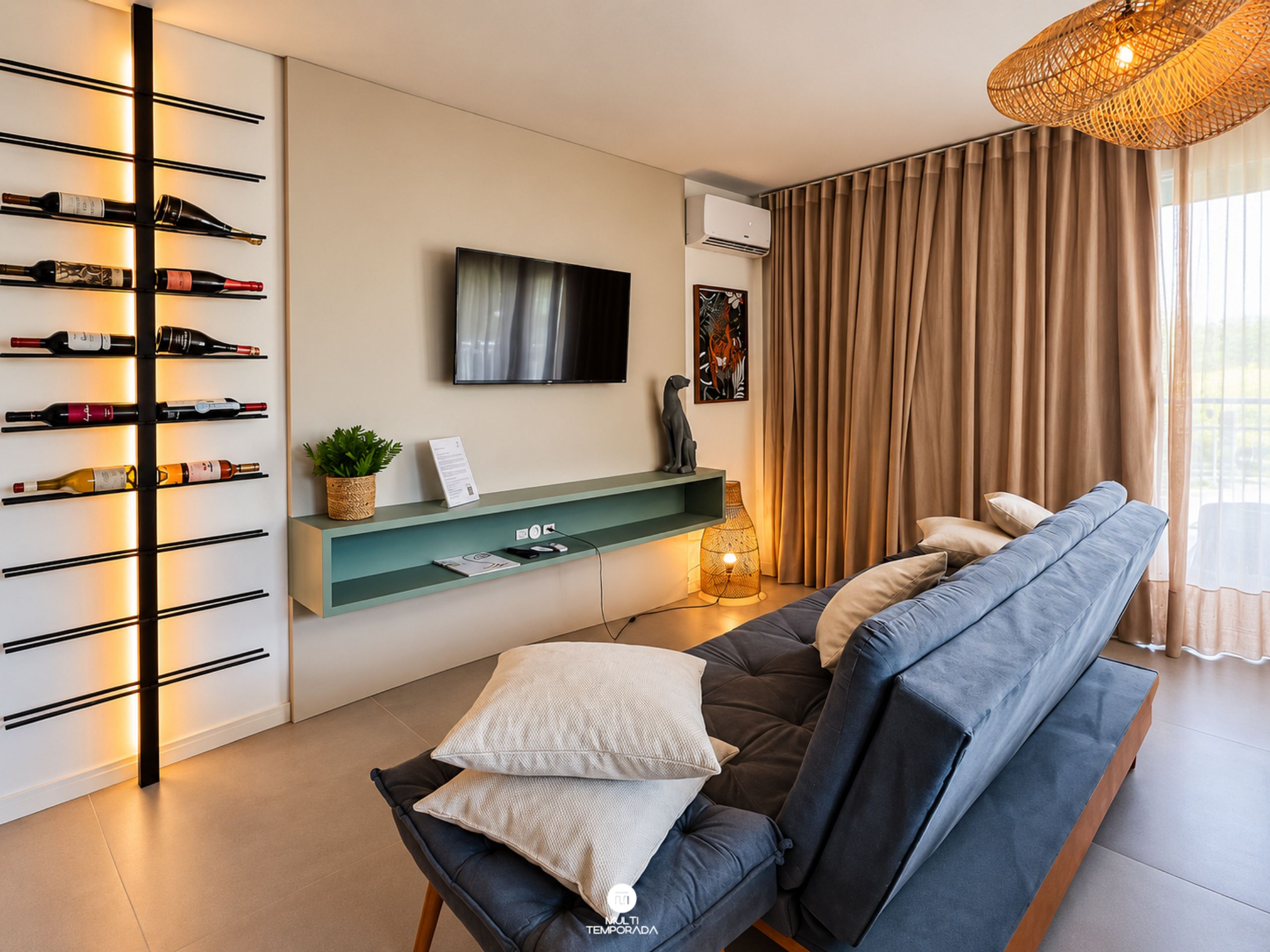 A modern living room with a sofa, a wine rack, a flat-screen TV, and a large window with curtains.