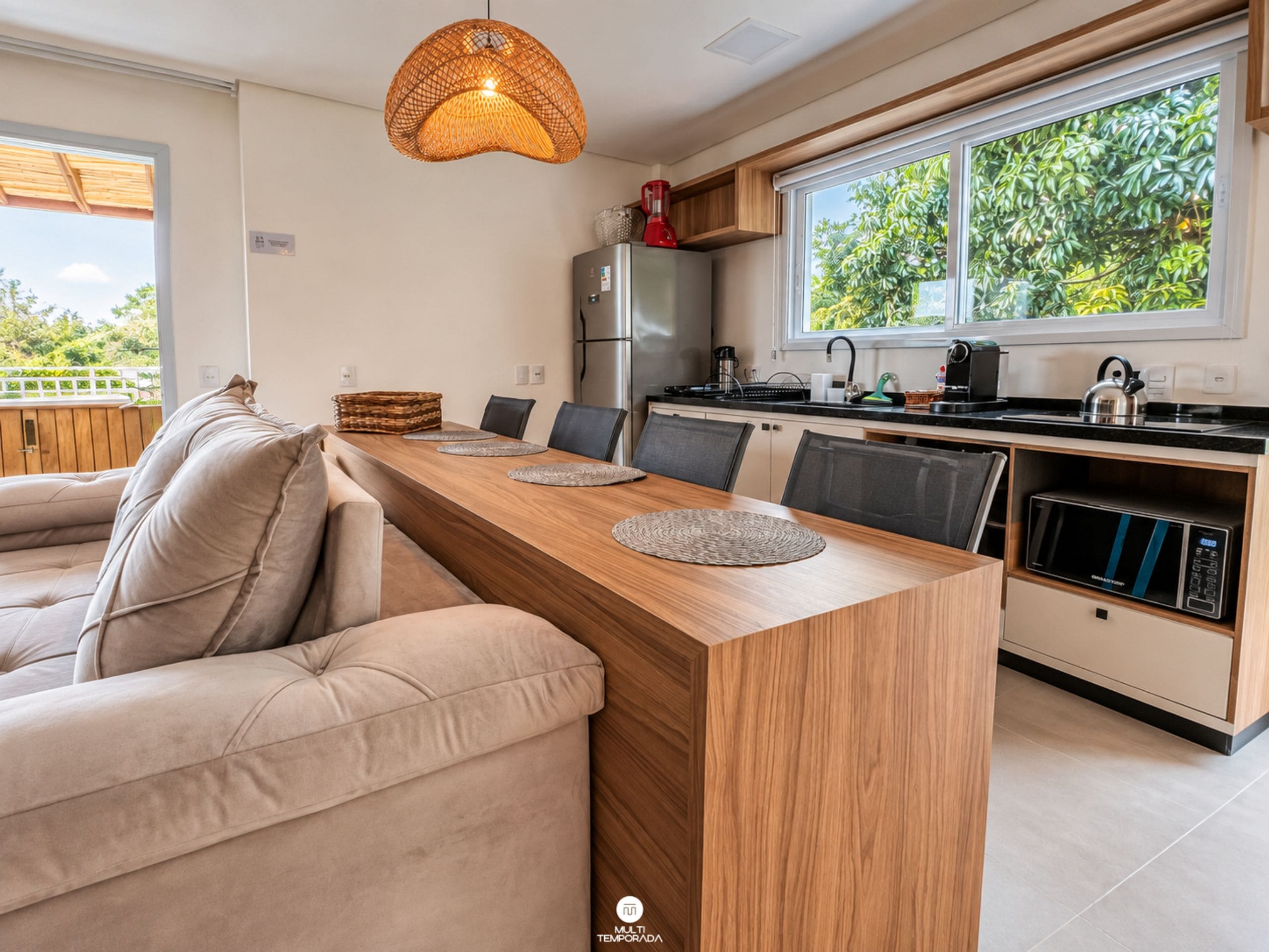 Una cocina moderna con una mesa de comedor de madera, sillas y un microondas integrado.