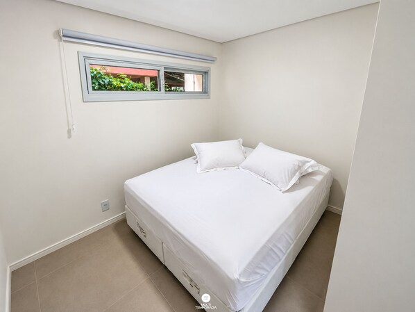 A bedroom with a single bed, a window with a view of greenery, and a tiled floor. - Villa Verde Bangalô - Garopaba - SC (Garopaba)