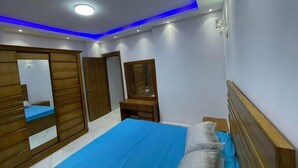 Un dormitorio con cama, armario, espejo y cómoda.