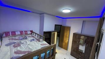 Une chambre à coucher avec un lit, une armoire et un miroir.