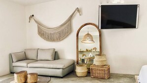 A living room with a sofa, a hammock, a mirror, and wicker baskets. - Casa Macay Tulum (Tulum)