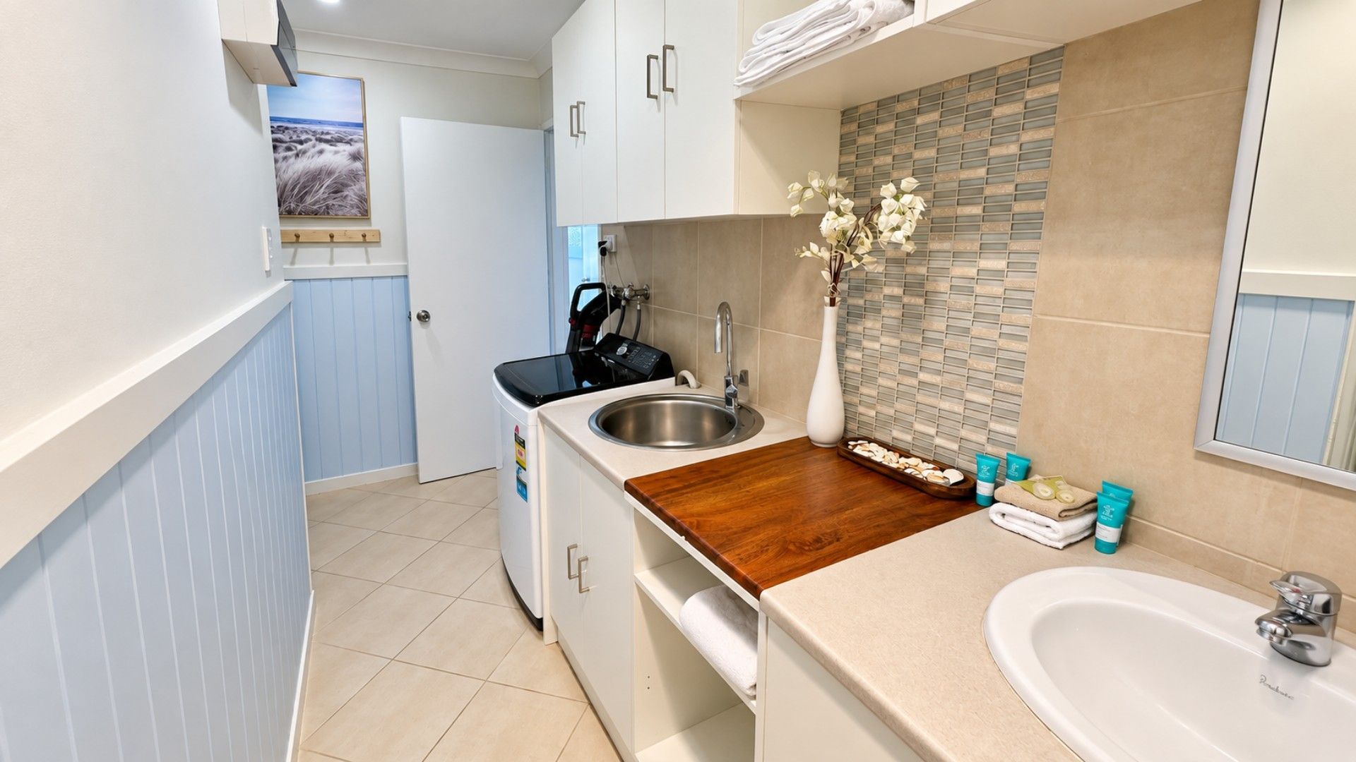 A compact kitchen with a wooden countertop, a sink, and a small dining area.