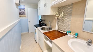 A compact kitchen with a wooden countertop, a sink, and a small dining area.