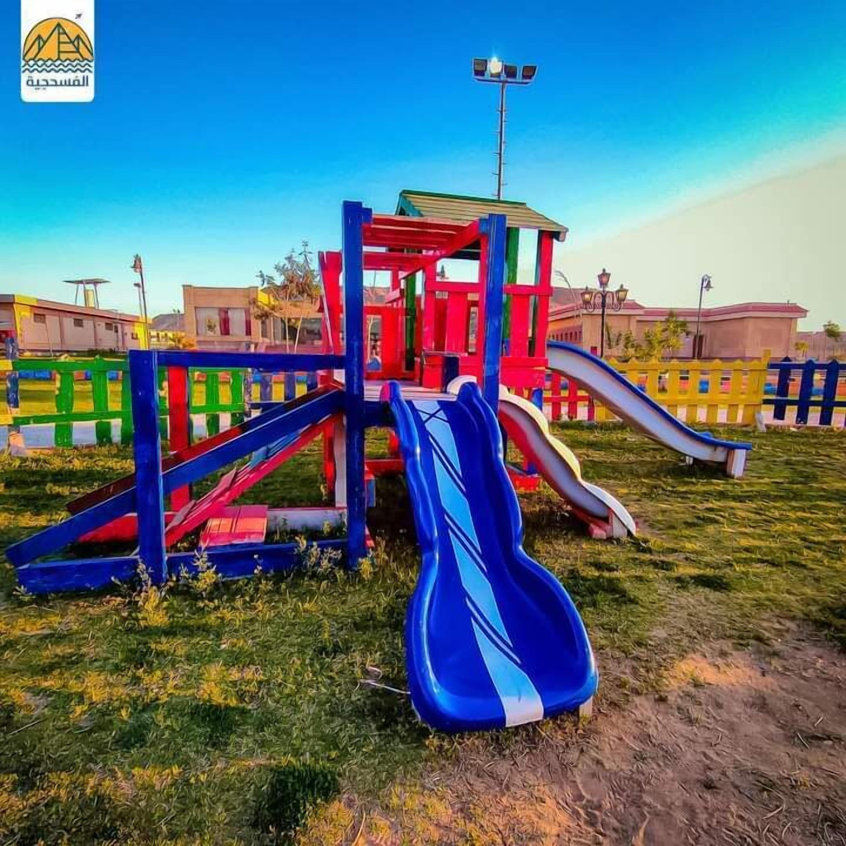 A playground with a slide and climbing structures.